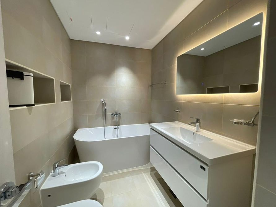 Marble ensuite bathroom with backlit mirror